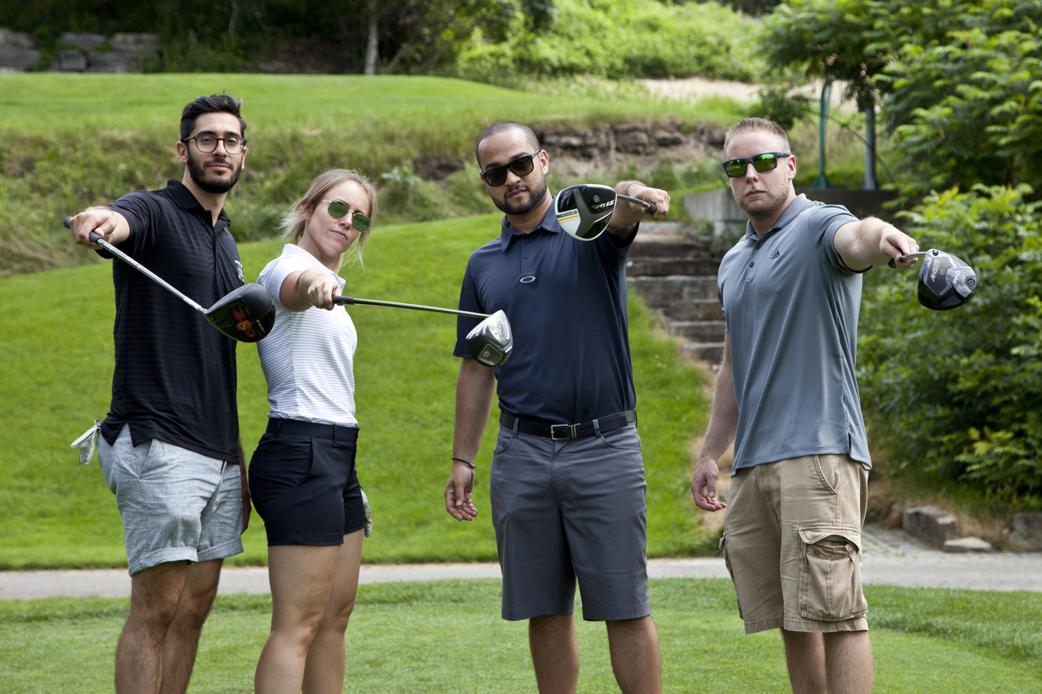 Four golf players pose with their clubs.