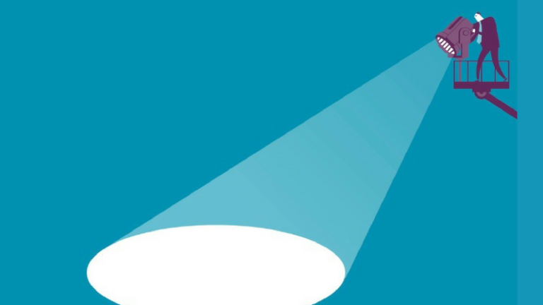 A businessman points a spotlight