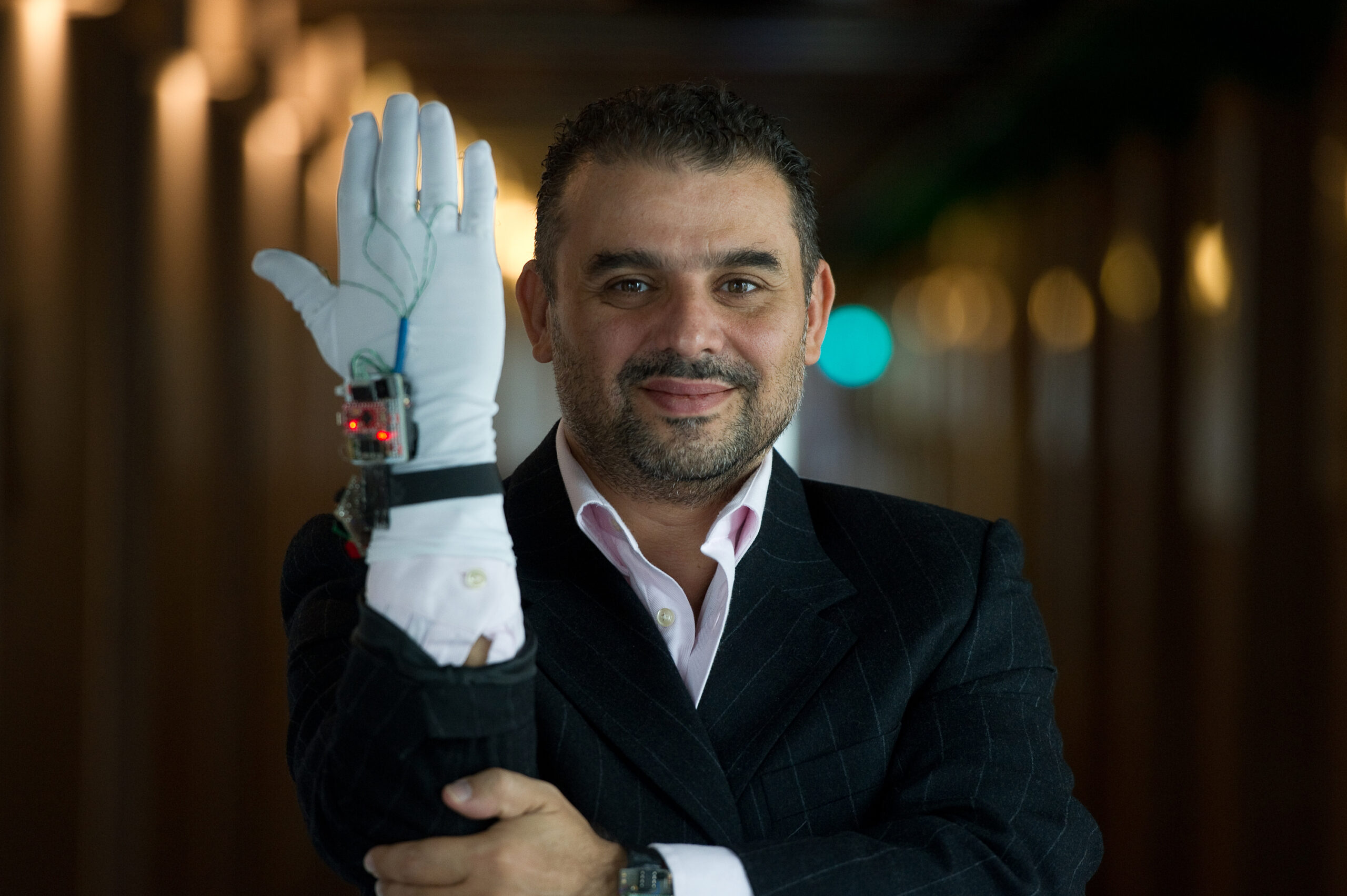 Dr. Abdulmotaleb El Saddik demonstrates a glove-based tool that responds to pressure.