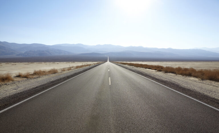 A long barren road into a sunny valley.
