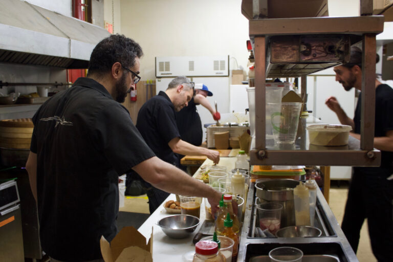 The GongFu Bao team prep food in a kitchen.