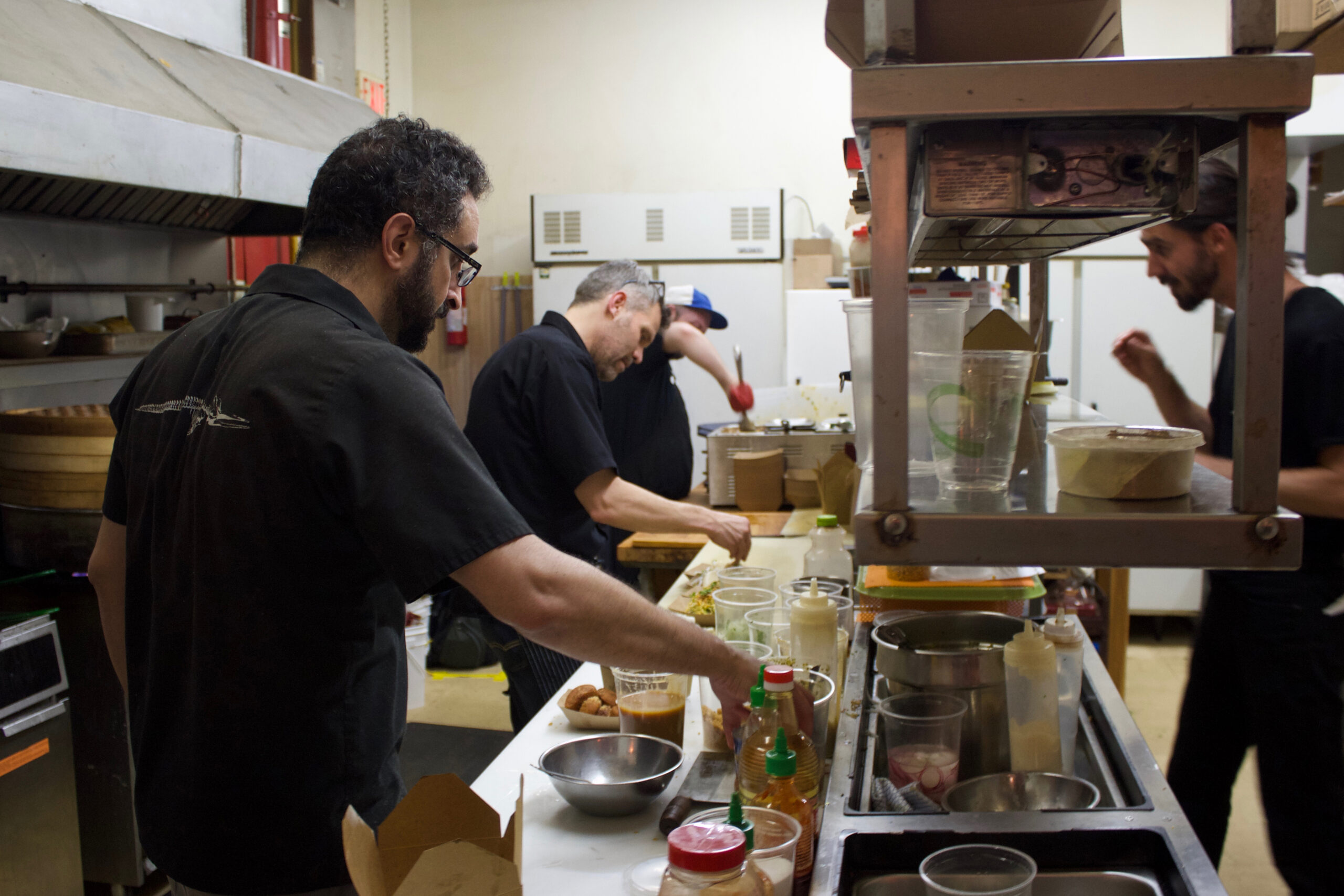 The GongFu Bao team prep food in a kitchen.