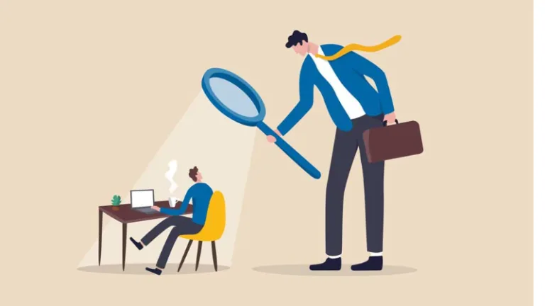An illustration of an oversized boss holding a magnifying glass over an employee sitting at their computer