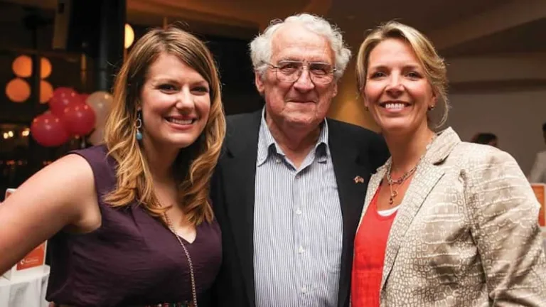 Two women and a man pose for a photo.
