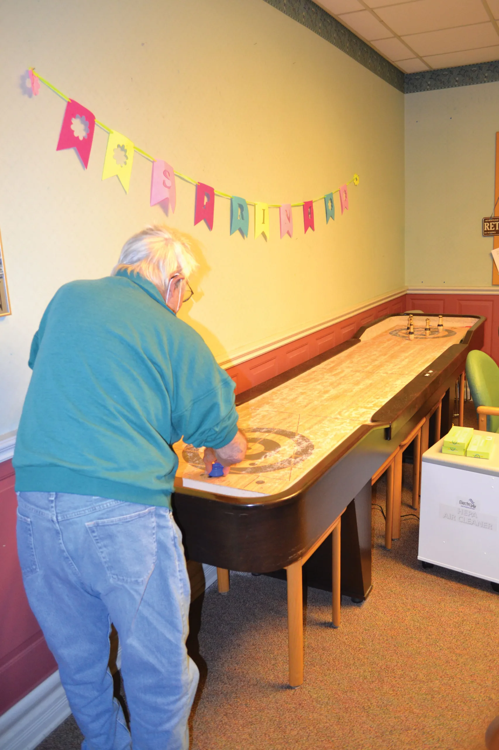 And elderly man plays shuffleboard