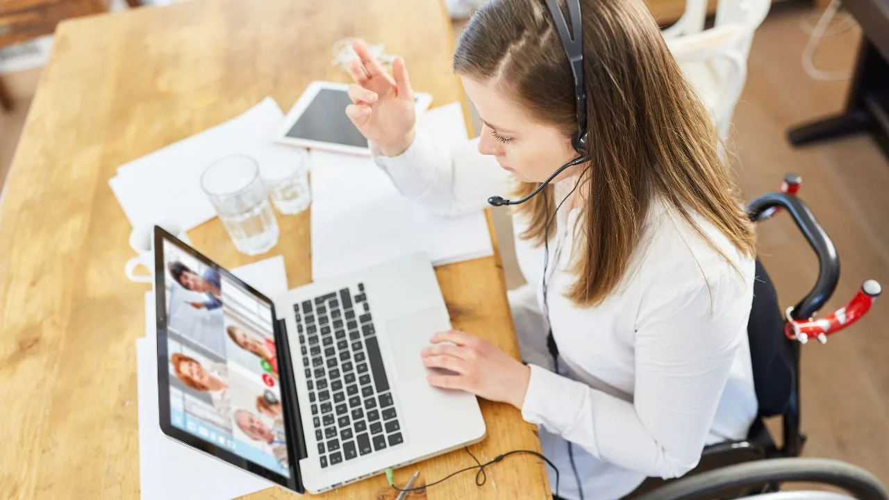 A woman participating in a virtual work meeting on her laptop