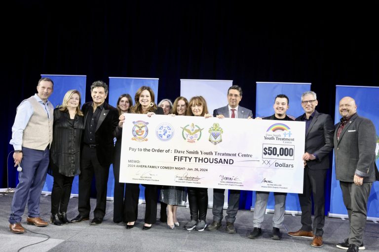 Supporters of the Dave Smith Youth Treatment Centre on stage at the Infinity Convention Centre on Friday, Jan. 26, 2024 with volunteers from the Ottawa AHEPA family to announce $50,000 raised at Stand-Up For A Cause. Photo by Caroline Phillips