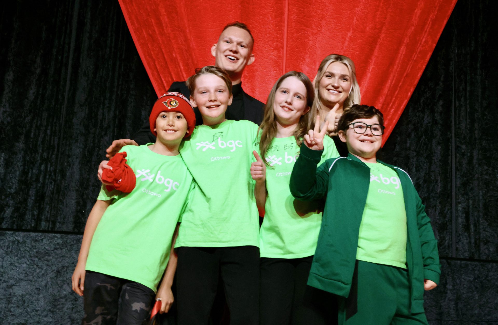 Ottawa Senators captain Brady Tkachuk and his wife Emma on stage during the CIBC Senators Black, Red & Gold Gala with kids from BGC Ottawa. Photo by Caroline Phillips