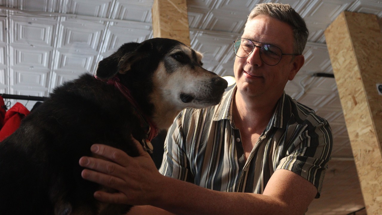 Kevin Martin, co-owner of Stroked Ego, says his 11-year-old dog Jasmine runs the store. He originally brought her to work to ease her separation anxiety. Photo © Zenith Wolfe