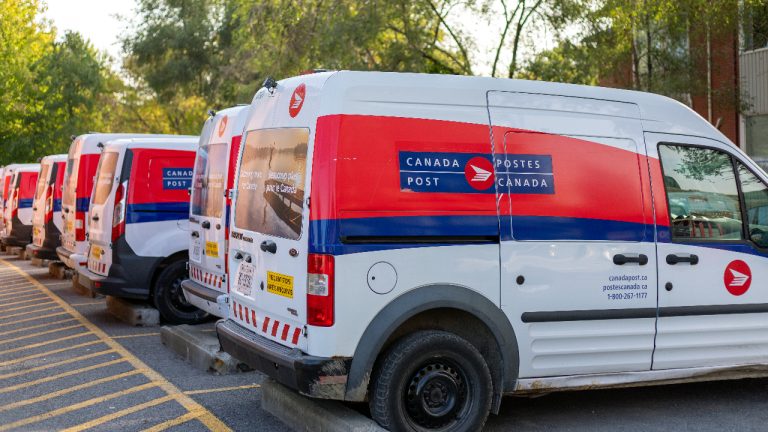 Canada Post trucks parked in a row.