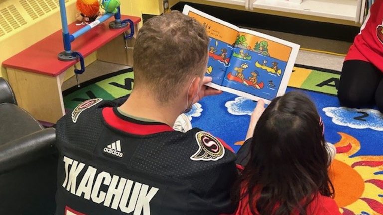 Brady Tkachuk, captain of the Ottawa Senators, reading with a child at the CHEO hospital. Photo provided.