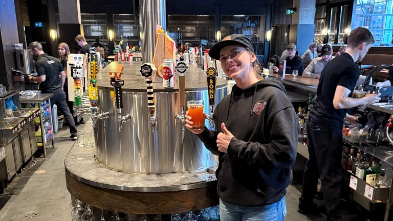 Emily Clark, star forward for the Ottawa Charge, with a pint of the "Ottawa Wheat 26" at the launch event on Wednesday, March 12. Photo by Brant Feldman/AGM.