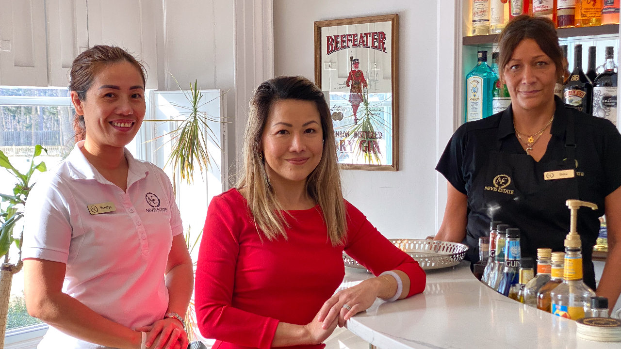 Nevis Estate owner Terri Hofan (middle, with staff members) in the hotel’s lobby bar. Photo by Laura Byrne Paquet.