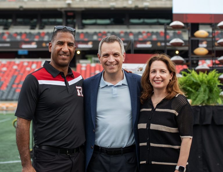 MC Jock Climie, retired CFL player and partner at Emond Harnden, with Mayor Mark Sutcliffe and wife Ginny Sutcliffe at Gourmet on the Gridiron, June 24, 2025. Photo by Tia MacPherson.