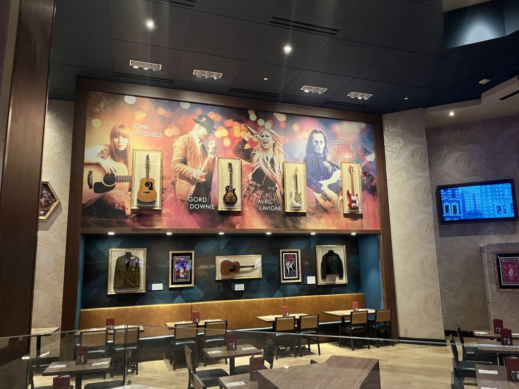 Guitars used by iconic Canadian artists Joni Mitchell, Gord Downie, Avril Lavigne and Geddy Lee are displayed next to the Hard Rock Café stage. Photo by Marissa Galko.