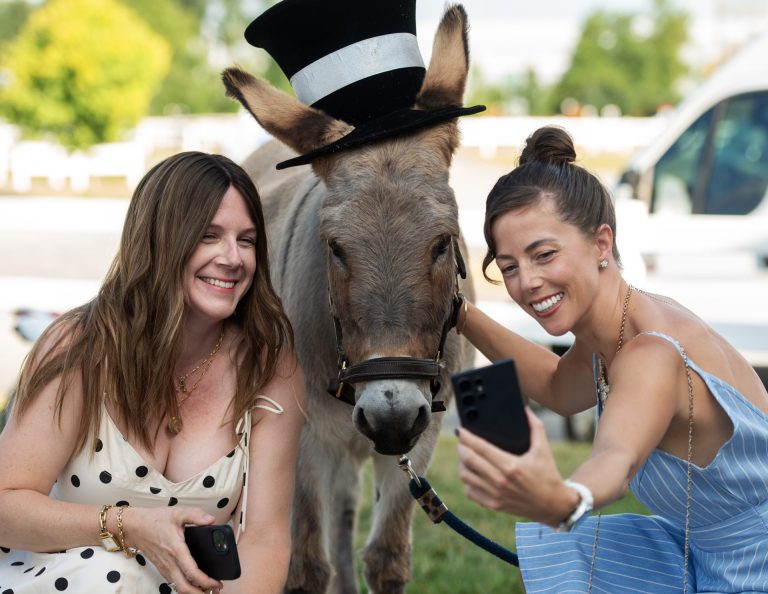 Ainsley Wing of Saddle & Roam with Meghan Malone take a selfie with Zak the donkey, at Spurs & Sparkles for QCH Foundation at Wesley Clover Park, August 13, 2025. Photo by Tia MacPherson.