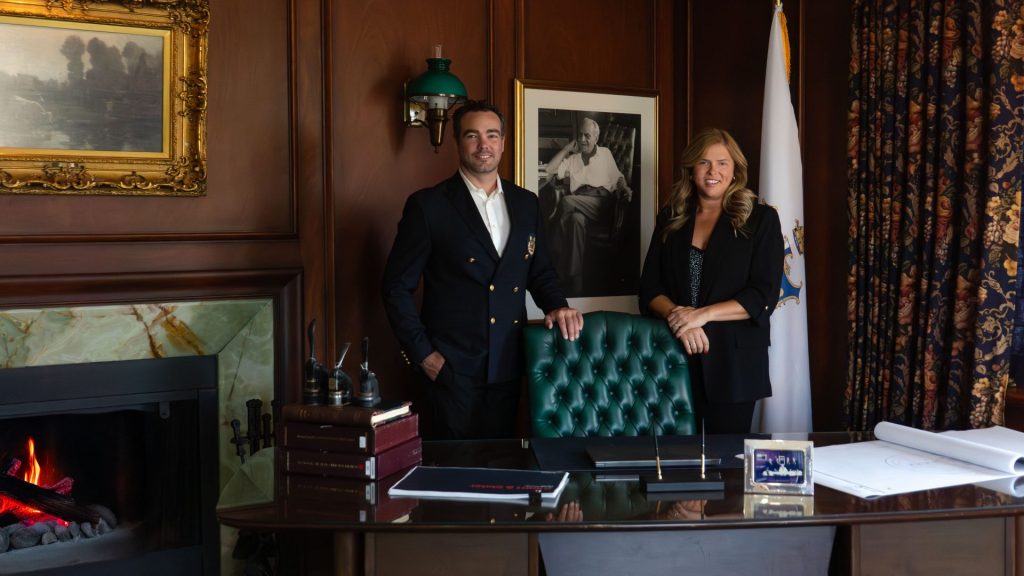 Samuel Fuller (left) and Jennifer Arbuckle in front of a portrait of their grandfather, Fuller Group founder Thomas G. Fuller. Photo supplied