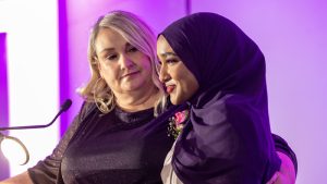 Delaila Salem is supported by MC Sam Laprade after delivering an emotional speech upon receiving the Outstanding Individual Youth Philanthropist award, nominated by BGC Ottawa and sponsored by OttawaU, during the AFP Ottawa Philanthropy Awards at the National Arts Centre on Nov. 20, 2025. Photo by Tia MacPherson for OBJ.