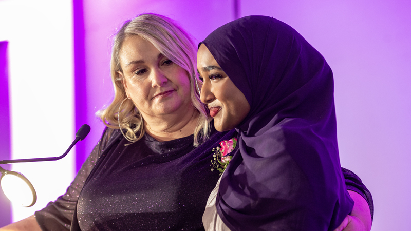 Delaila Salem is supported by MC Sam Laprade after delivering an emotional speech upon receiving the Outstanding Individual Youth Philanthropist award, nominated by BGC Ottawa and sponsored by OttawaU, during the AFP Ottawa Philanthropy Awards at the National Arts Centre on Nov. 20, 2025. Photo by Tia MacPherson for OBJ.