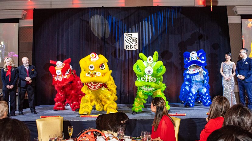 Joanne Jacques, Dion Farentino of RBC, left, Ada Chen, Parker Zhan of RBC, right, on stage with the Success Dragon Lion Dance Troupe, middle, at the RBC Lunar New Year Gala at the Infinity Convention Centre in Ottawa on Feb. 19, 2026. Photo  Tia MacPherson for OBJ.