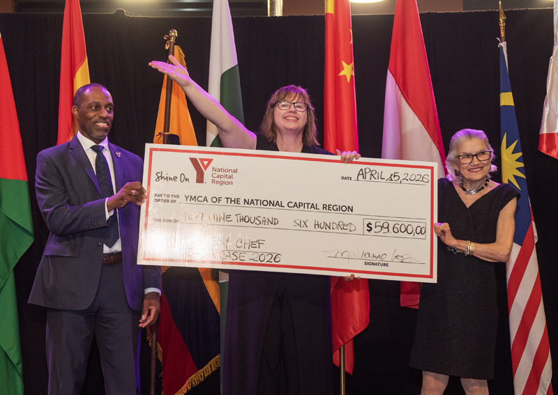 Trevor McAlmont (YMCA CEO), Marianne Long (YMCA) and Margaret Dickenson (honorary chair) present a cheque for $59,600 raised in support of YMCA programs during the Y Embassy Chef Showcase at Lansdowne Park, Ottawa, April 15, 2026. Photo by Tia MacPherson for OBJ.