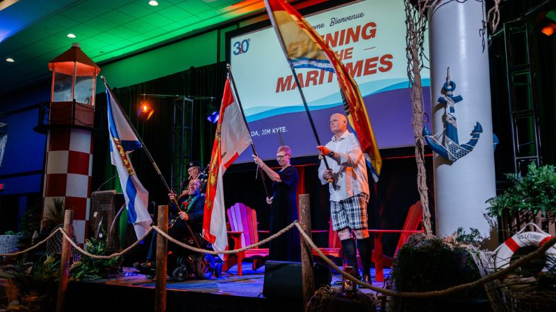Evening in the Maritimes Honourary Chair Michael Lifshitz, ABLE2 Executive Director Heather Lacey, and former NHL player and ABLE2 champion Jim Kyte kick off the 30th anniversary celebration with a ceremonial flag presentation representing the three East Coast provinces.