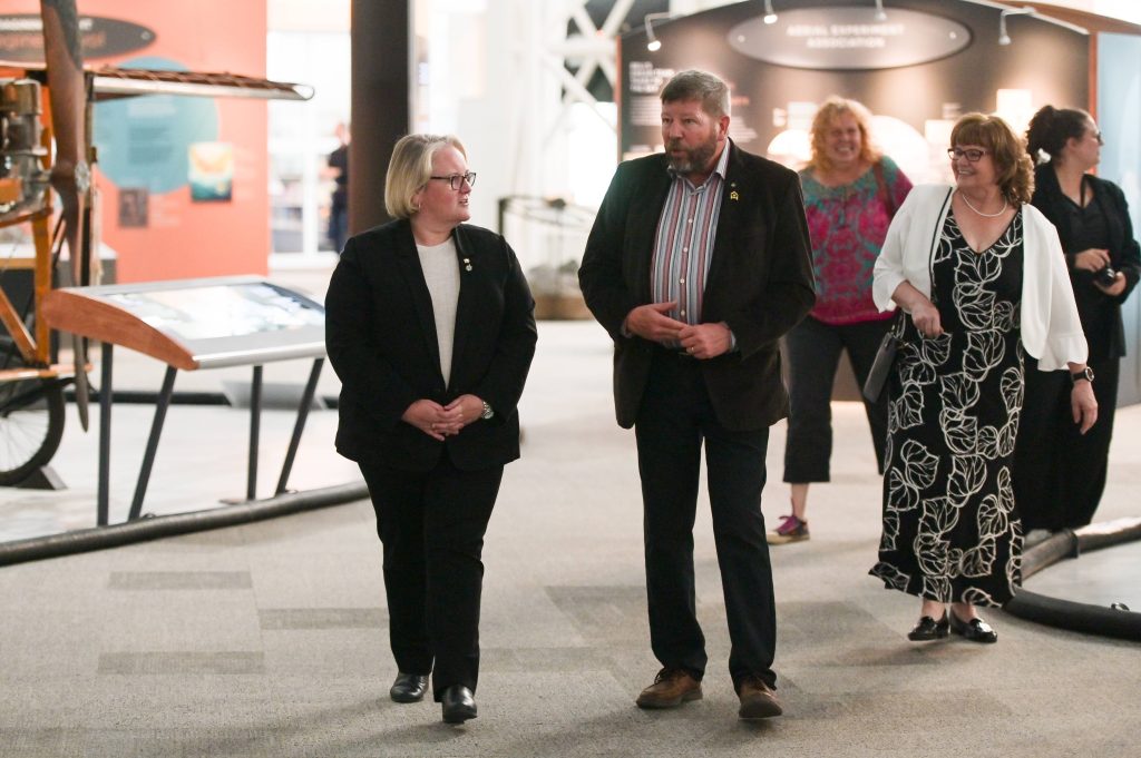 The Honourable Jill McKnight (Minister of Veterans Affairs), BGen (Ret’d) Alan Mulawyshyn (Executive Director, VHC), and Amanda Mulawyshyn (event organizer) arrive at Veterans’ House Canada’s Andy Carswell Building 5th Anniversary celebration at the Canadian Aviation and Space Museum.