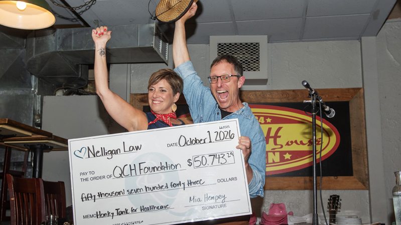 John Ouellette (QCHF) and Mia Hempey (QCHF/Nelligan Law) reveal the amount raised for the QCH Foundation at the Elmdale Oyster House & Tavern for Honky Tonk for Healthcare, in support of the Queensway Carleton Hospital Foundation, Oct. 1, 2026. Photos by Tia MacPherson-Abdulla/OBJ.