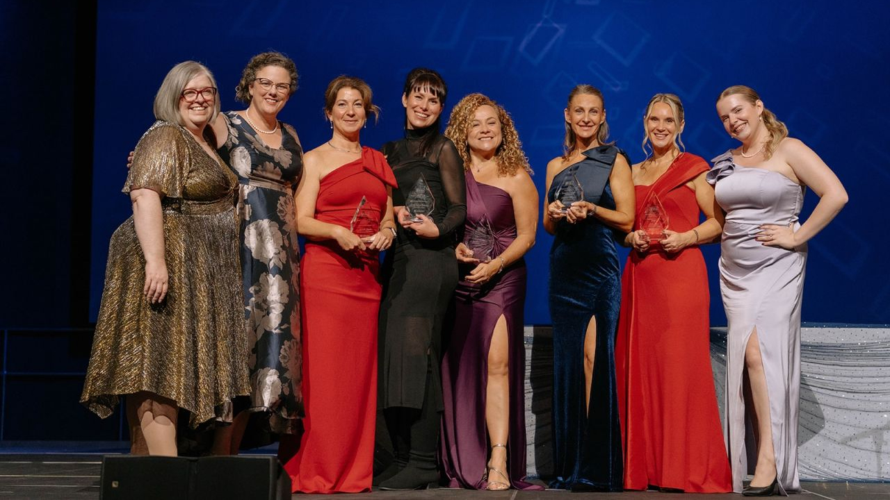 Members of the WBN and BYA recipients on-stage at the BYA gala on Oct. 14, 2026. From left to right: Karen Wilson, president of the WBN National Capital Region; gala co-chair Jennifer Reynolds; Michelle Groulx; Emily Jones Joanisse; Francesca Davila; Christine Harrison; Julia Reid; gala co-chair Caitlin Spearing. Photo by Ashley Notley.