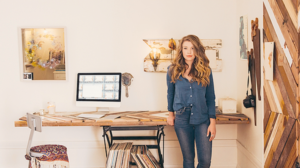 A woman stands in a home office.