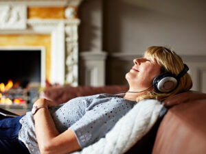 A woman leans back while listening to music.